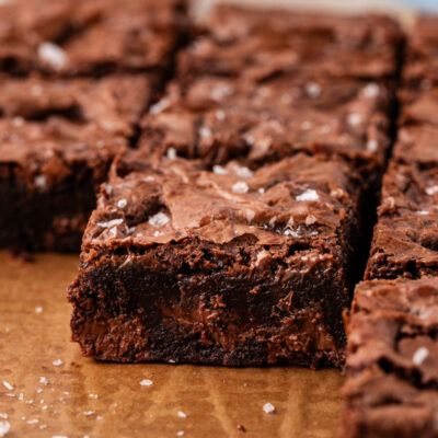 Close up of chocolate chunk brownies on a piece of parchment paper.