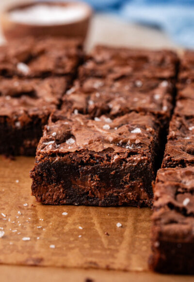 Close up of chocolate chunk brownies on a piece of parchment paper.