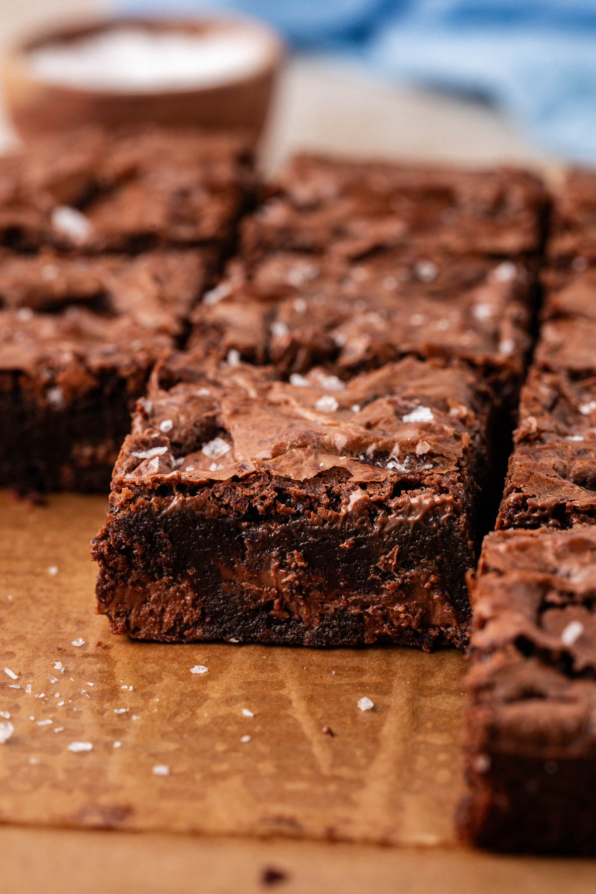 Close up of chocolate chunk brownies on a piece of parchment paper.