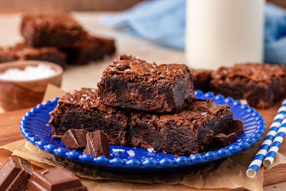 Three chocolate chunk brownies on a plate.