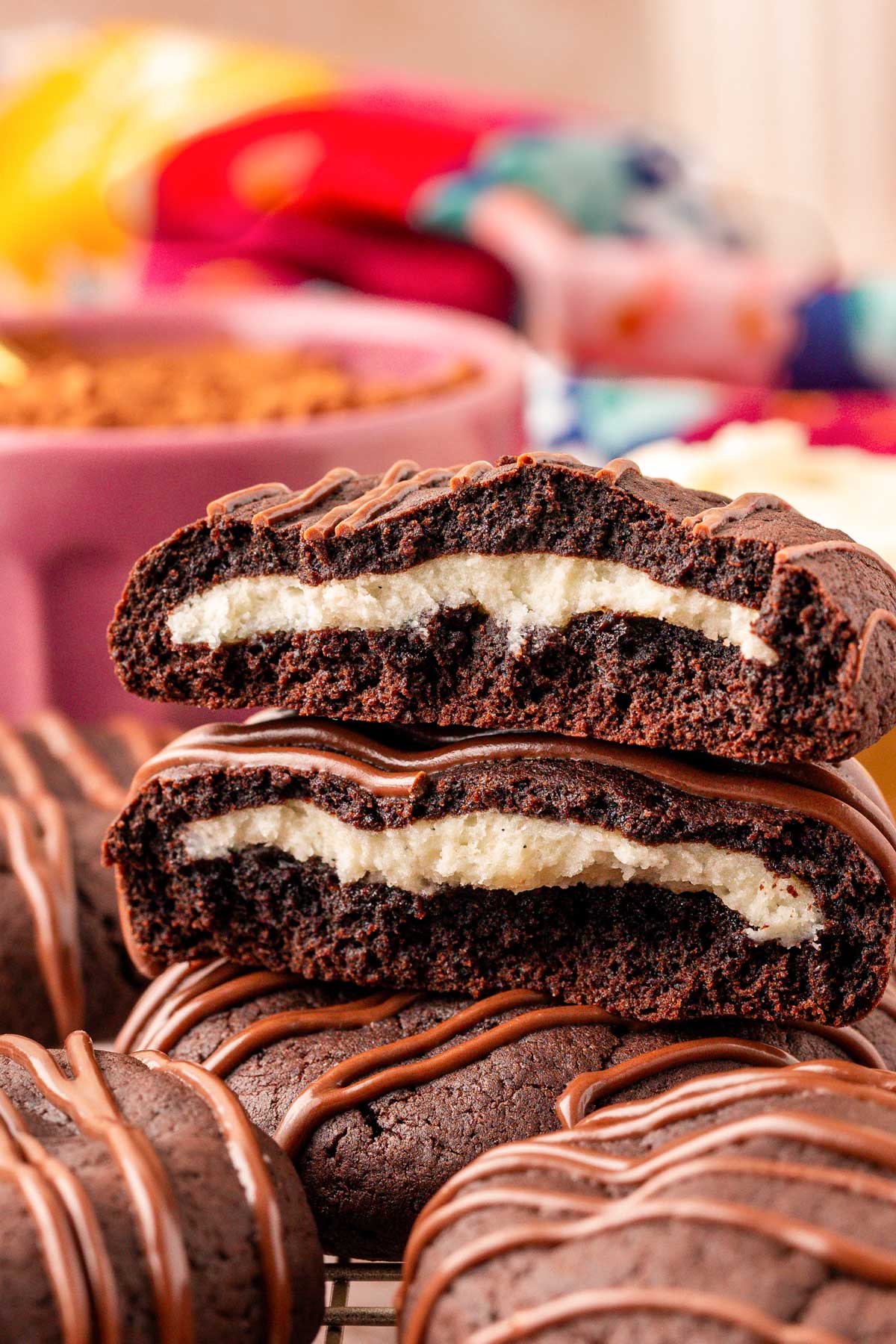 Close up og chocolate cookies stuffed with cream cheese. The top cookie has been broken in half and stacked to show the inside.