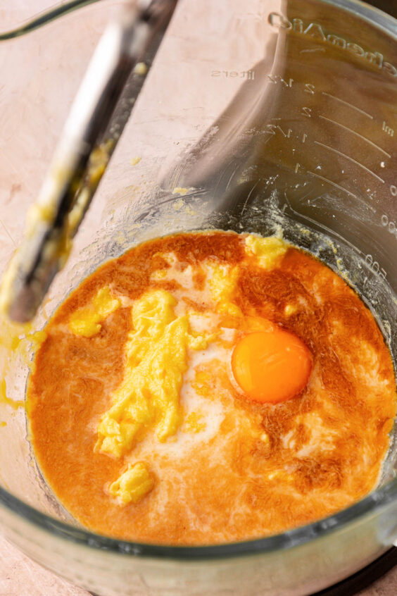 Egg and vanilla being added to other wet ingredients to make cookie dough.