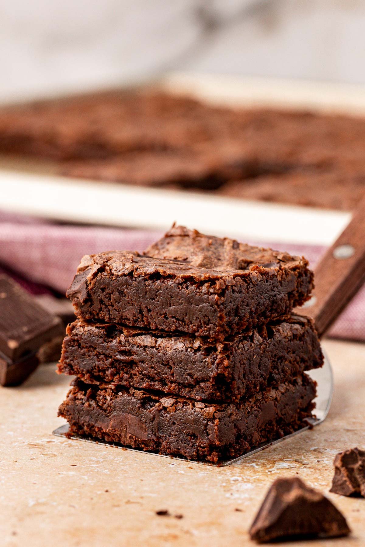 A stack of three thin brownies on a table.