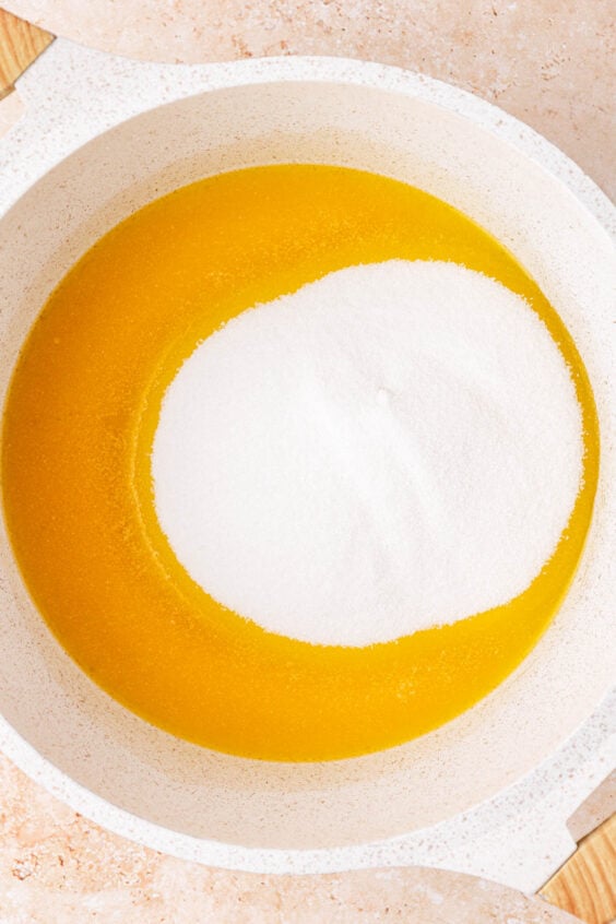 Sugar is added to melted butter in a saucepan.