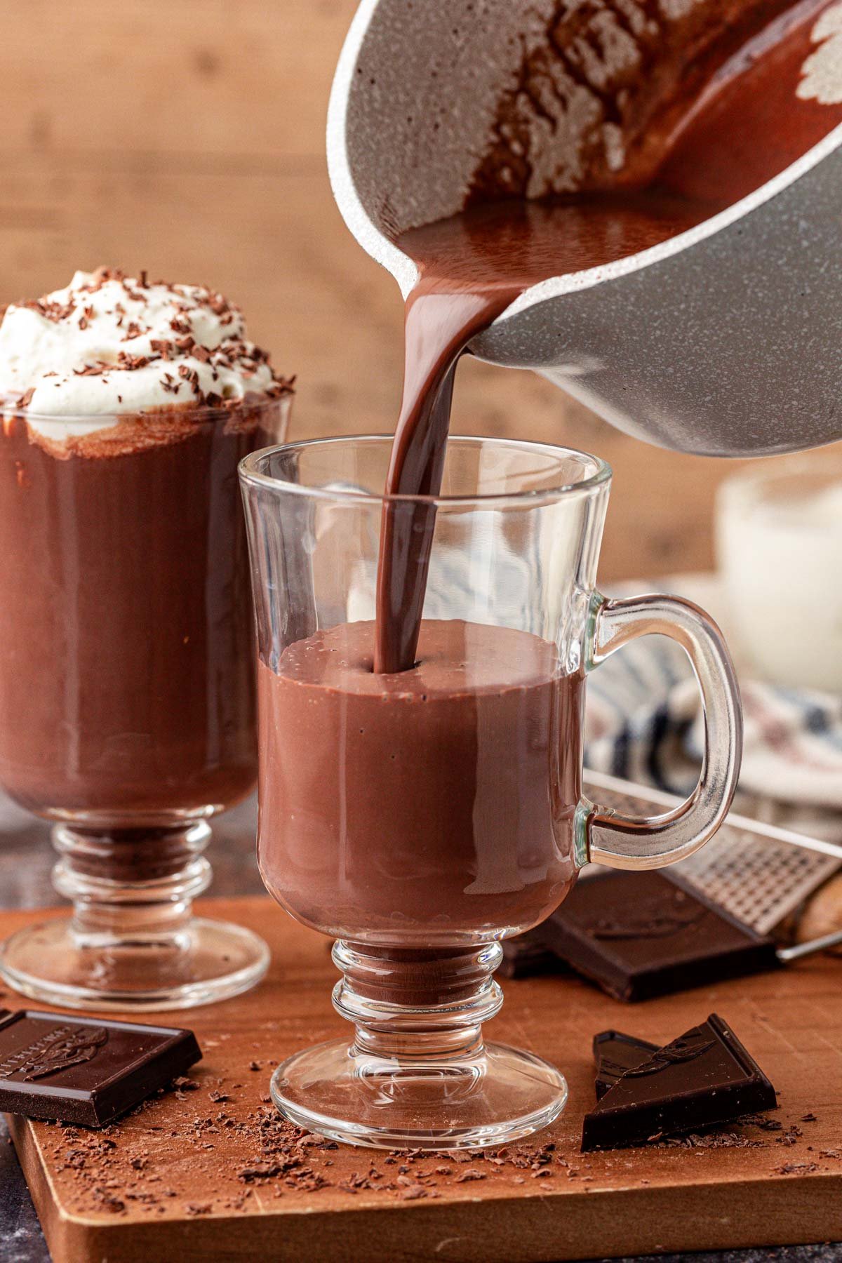 Hot chocolate being poured into a glass mug.