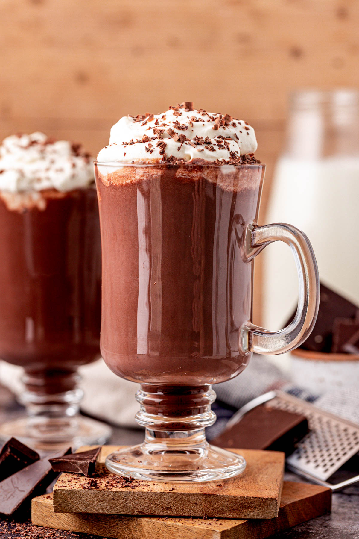 Close up of a mug of hot chocolate on a wooden coaster.