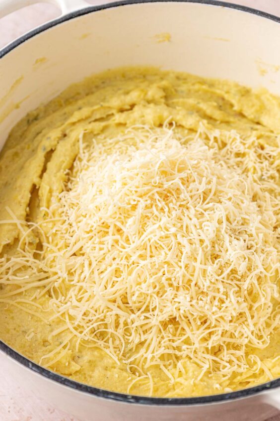 Parmesan grated into a pot of mashed potatoes.