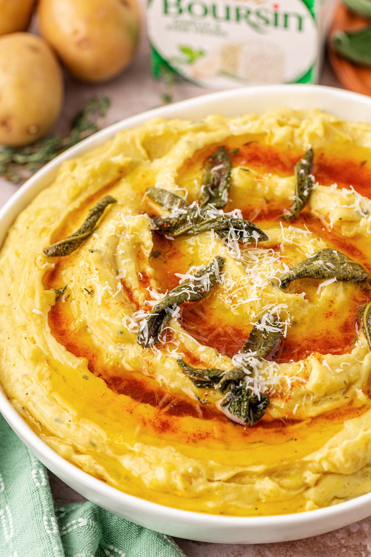 Close up of a bowl of mashed potatoes with brown butter on top.