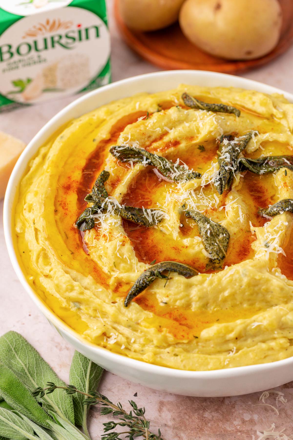 A bowl of mashed potatoes with brown butter and boursin cheese in a bowl.