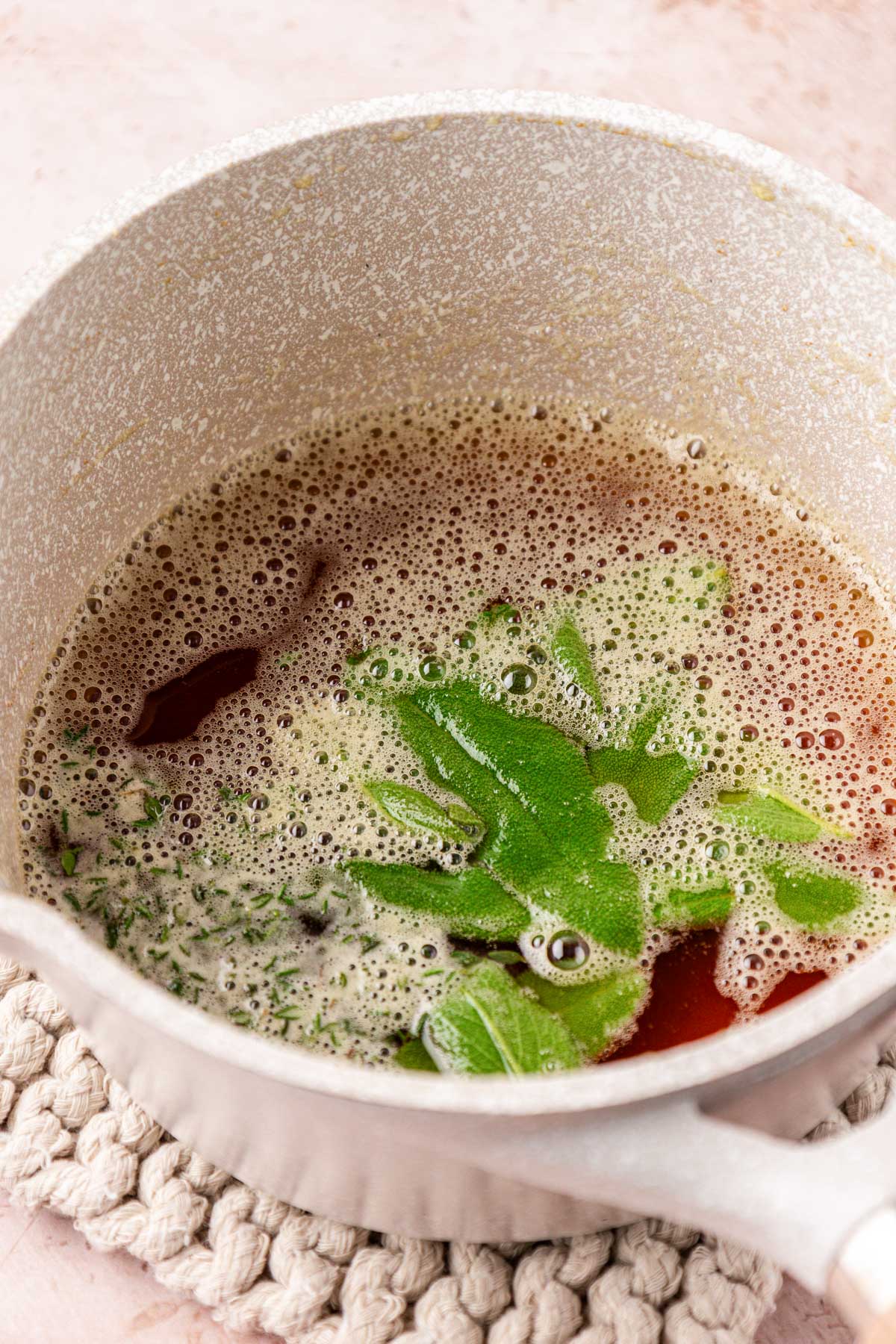 Herbs and brown butter in a small pot.