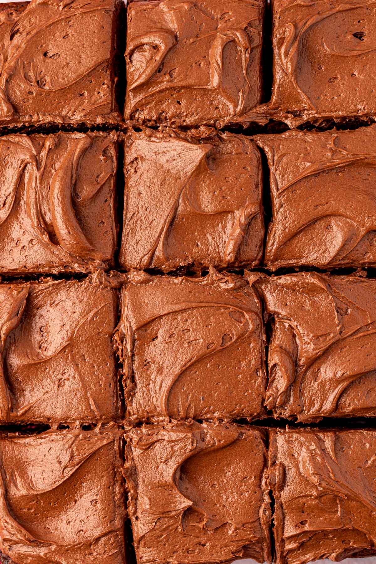 Overhead close up of cut brownies with frosting.