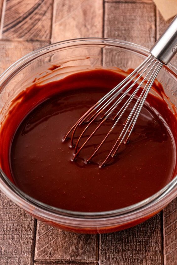 Ganache being whisked in a glass bowl.