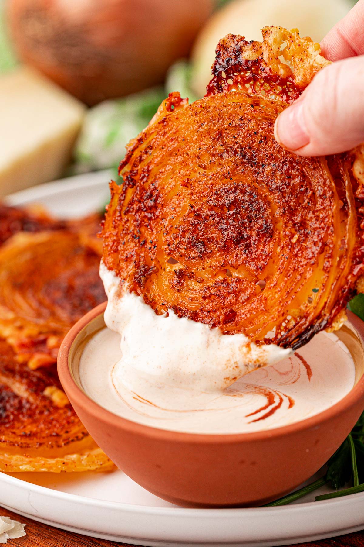 Onion ring chips being dipped in dressing.